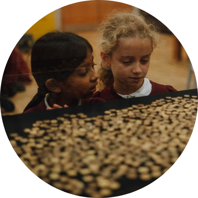 Two schoolgirls looking at coins in display case