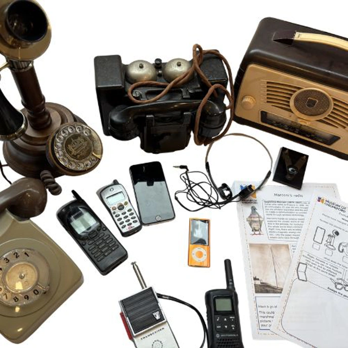 Collection of vinage communication equipment, including old telephones and mobiles