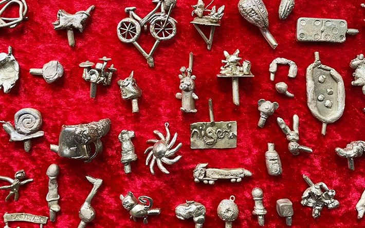 A selection of small bronze objects on a red background